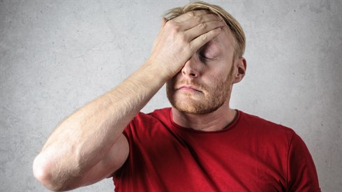 a-man-in-red-shirt-covering-his-face-3760043.jpg